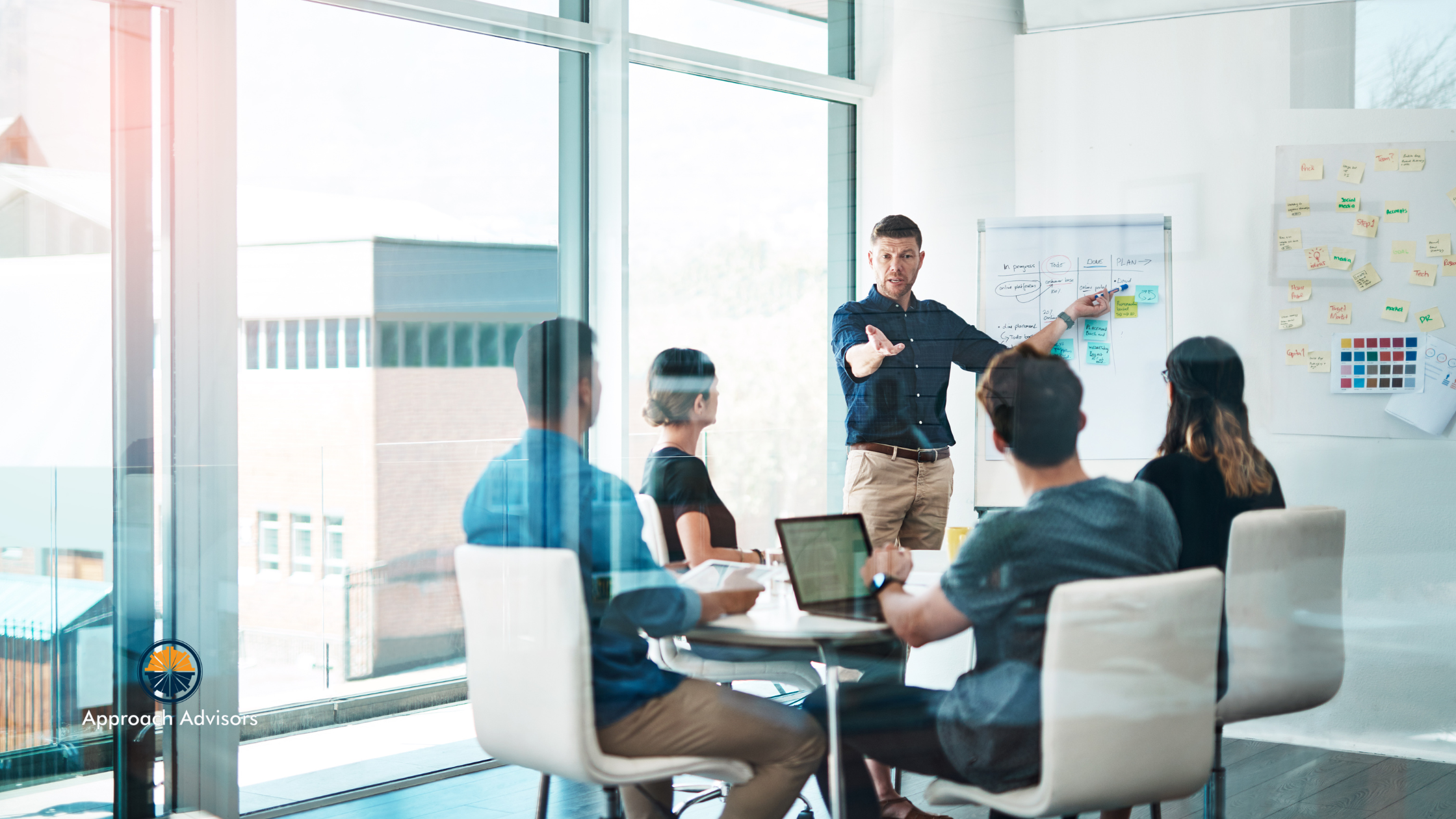 Team in a conference room conducting a content strategy analysis, with a leader presenting workflow and content planning on a whiteboard.