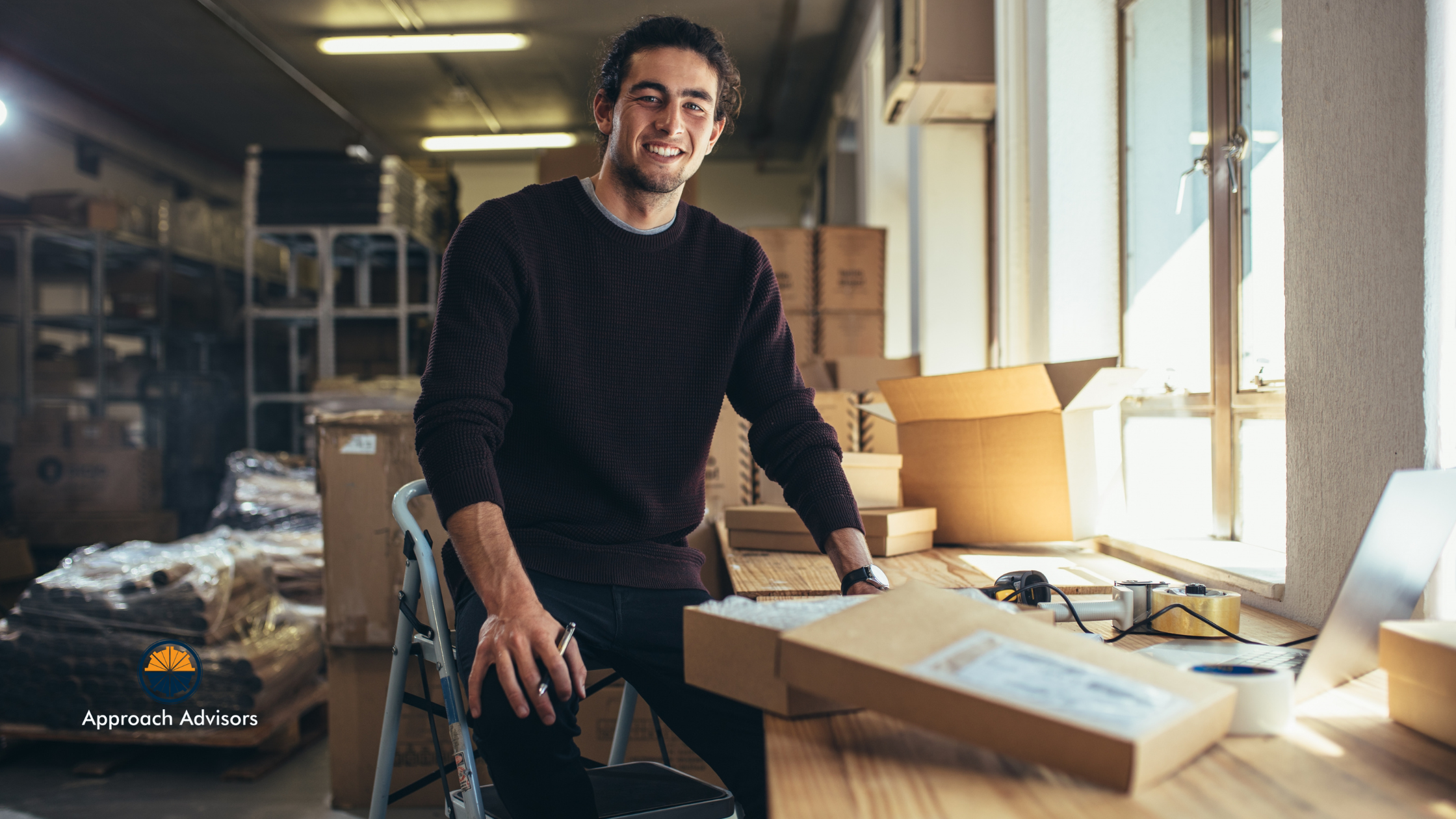 Small business owner smiling in a warehouse while preparing shipments, highlighting the importance of Financial Planning for inventory and cash flow management.