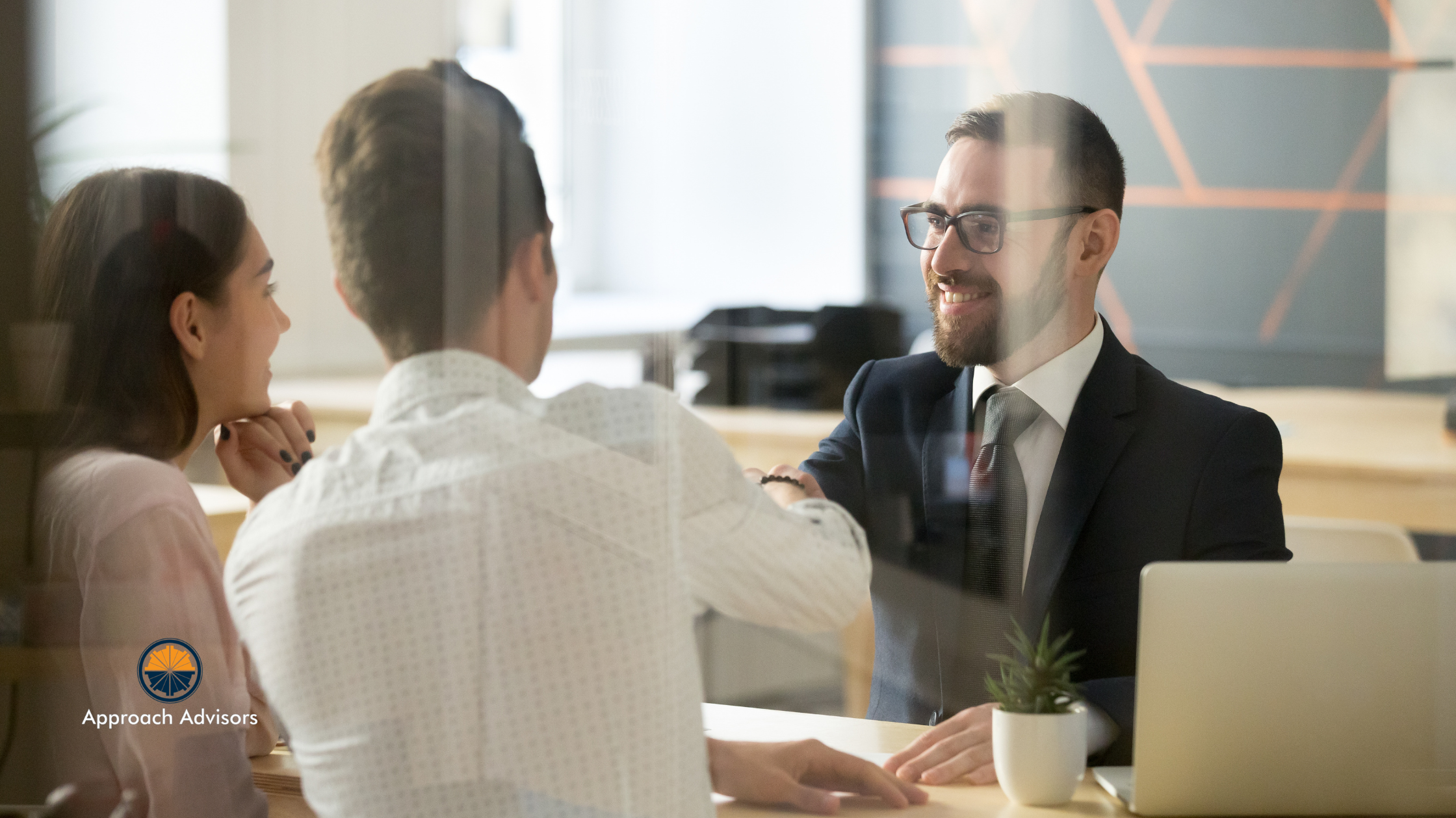 Financial advisor shaking hands with clients in a modern office, discussing financial planning and operational efficiency strategies.
